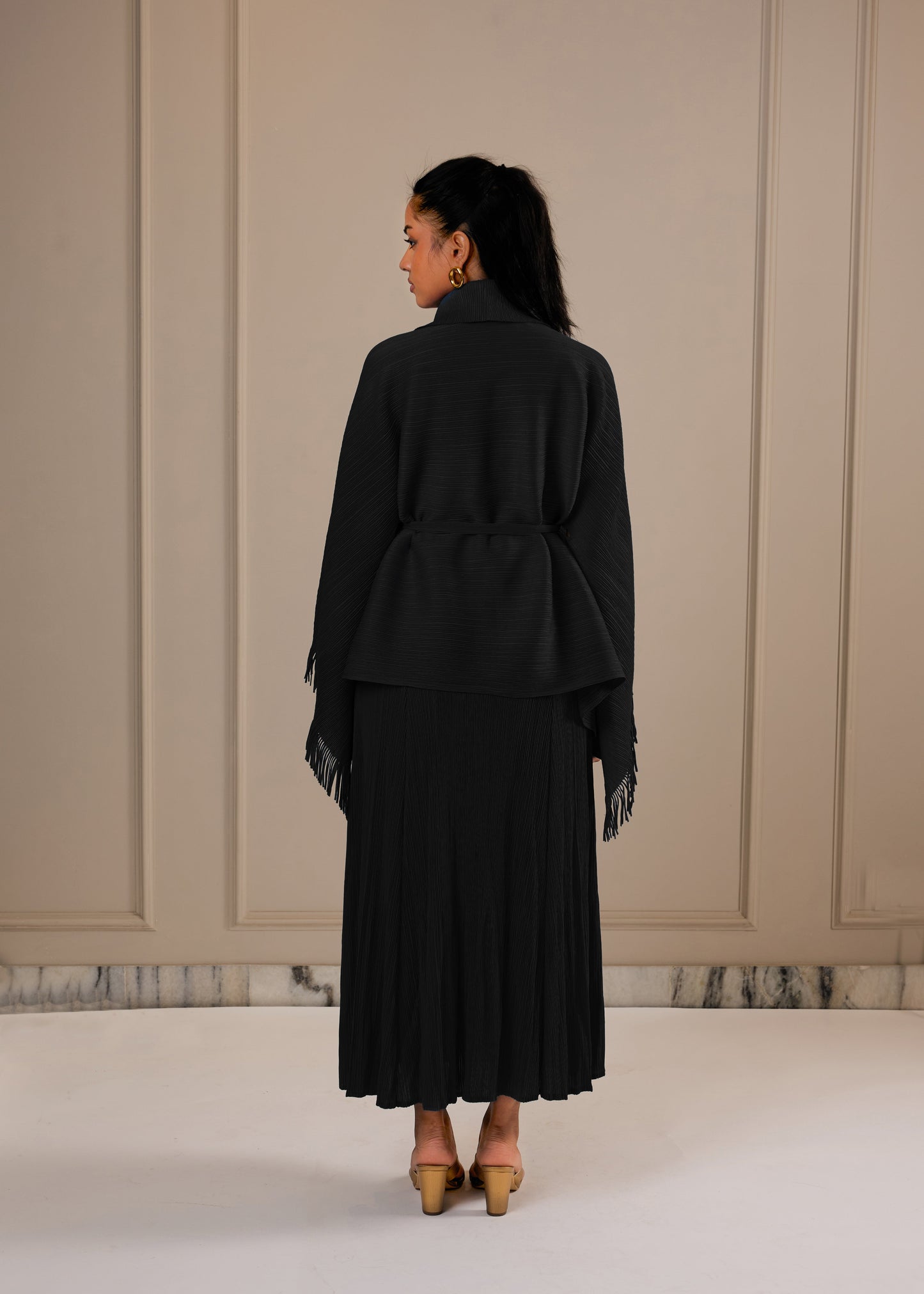 Woman wearing Black A line dress with Fringe cape and a belt