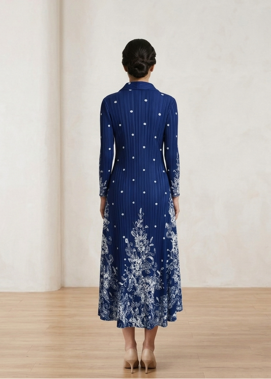 Woman wearing a blue dress with floral patterns in a minimalistic setting