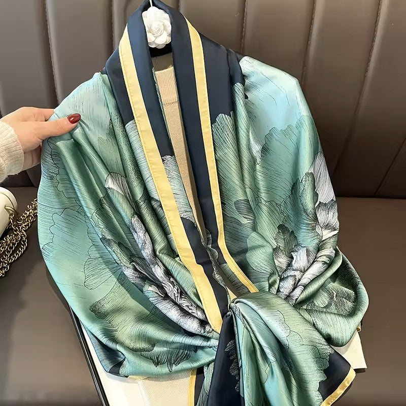 Green floral patterned scarf with black and yellow accents draped over a chair.