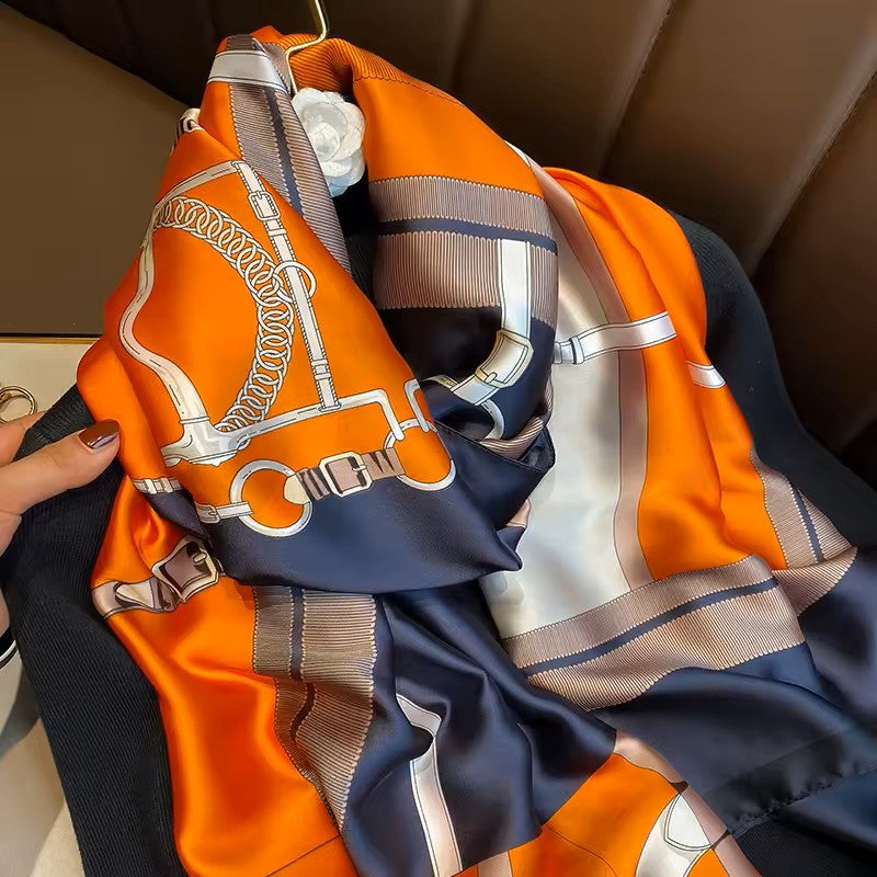 Colorful scarf with horsebit pattern draped over a surface