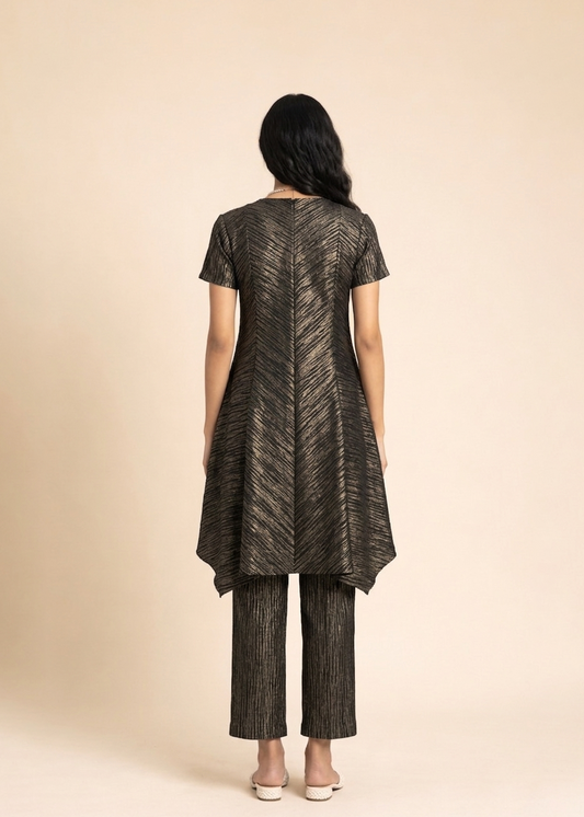 Woman wearing a black and gold patterned outfit on a beige background