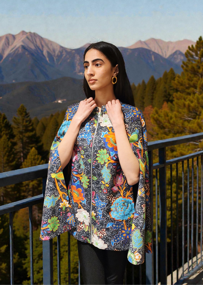 Woman wearing a colorful floral jacket with mountains and trees in the background