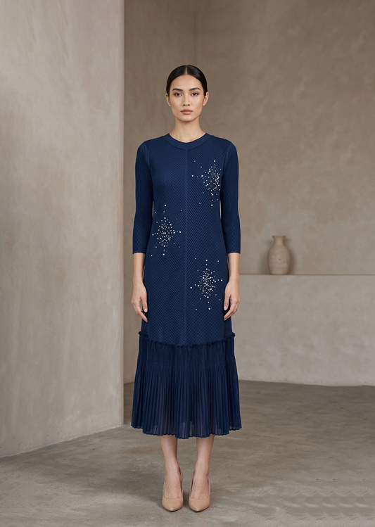 Woman wearing a navy dress with star patterns against a beige background