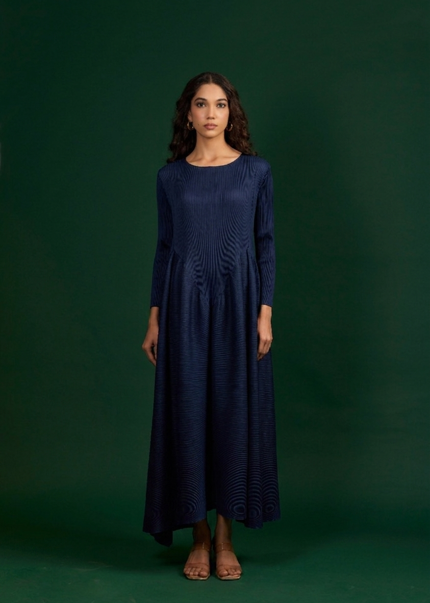 Woman wearing a navy blue dress against a green background