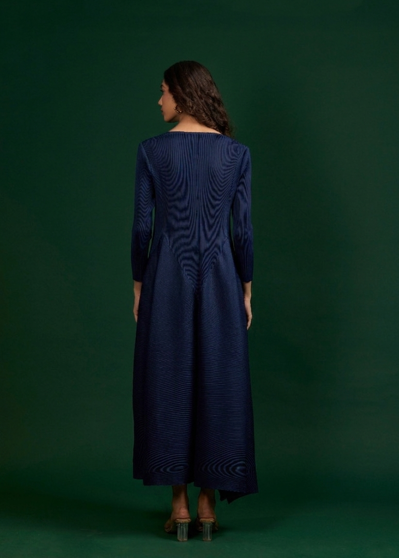 Woman wearing a navy blue dress against a dark green background