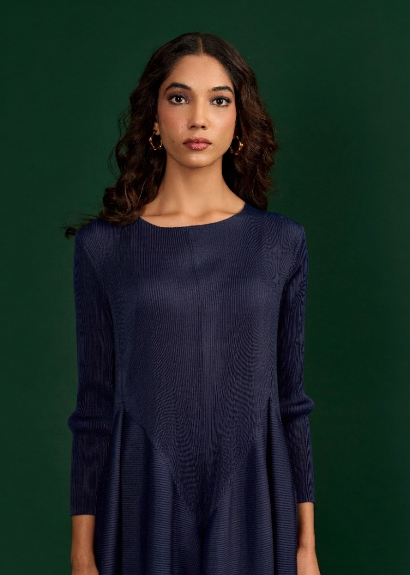 Woman wearing a dark blue dress against a green background