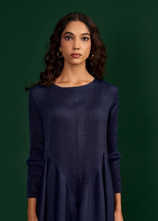 Woman wearing a dark blue dress against a green background