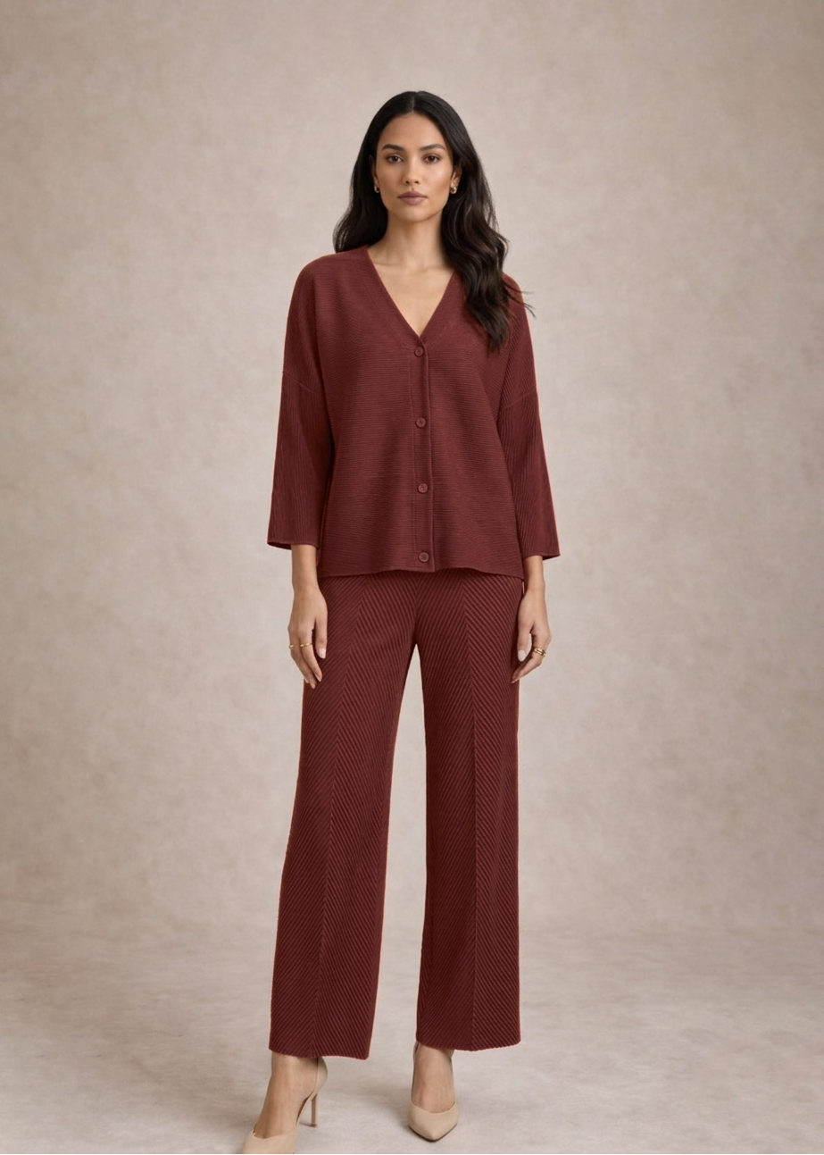 Woman wearing a burgundy outfit with a matching top and pants on a beige background