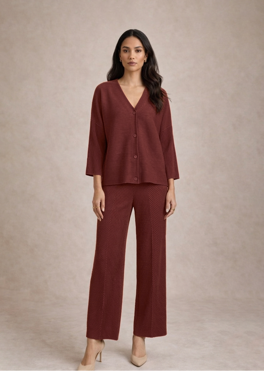 Woman wearing a burgundy outfit with a matching top and pants on a beige background