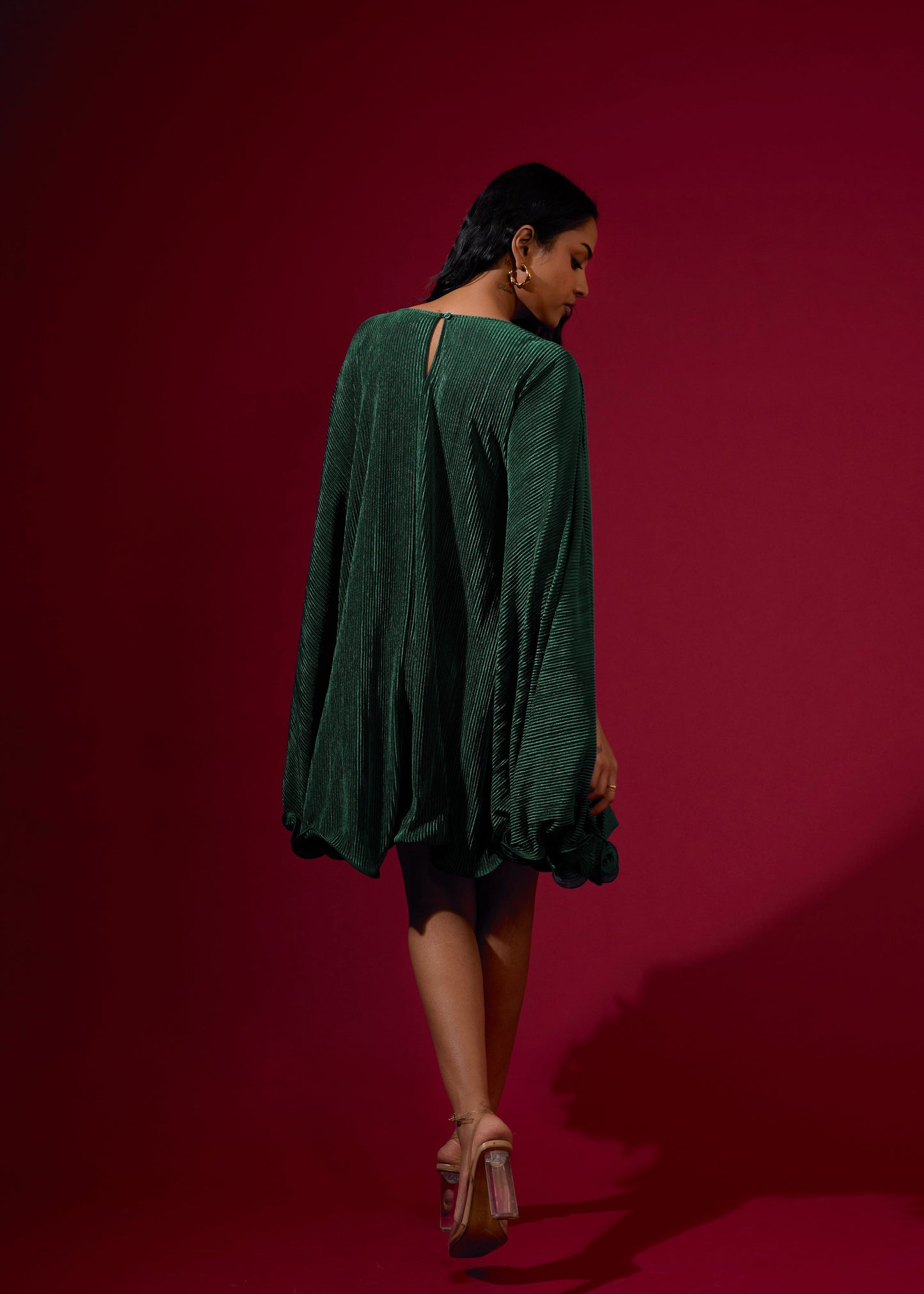 Woman wearing a green dress against a red background