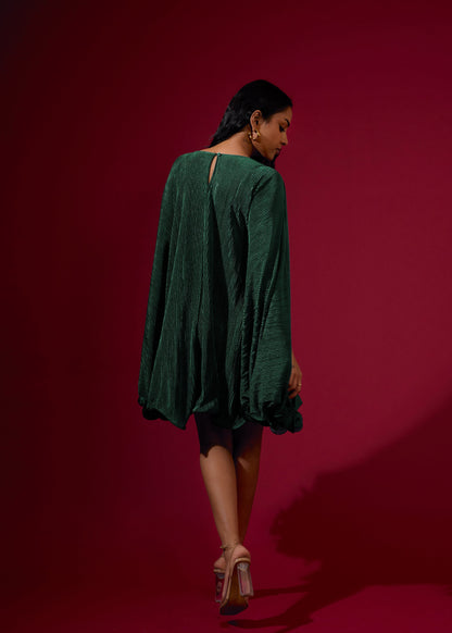 Woman wearing a green dress against a red background