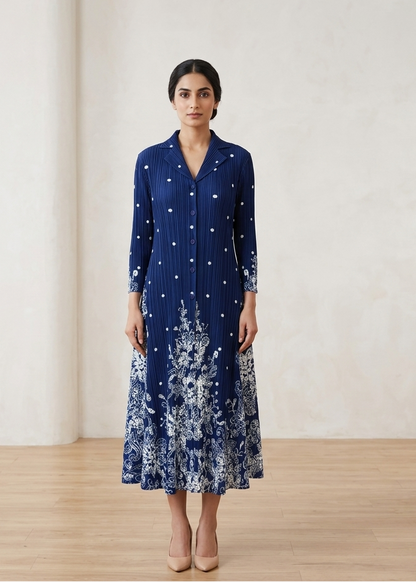 Woman wearing a blue dress with white floral patterns in a minimalistic setting