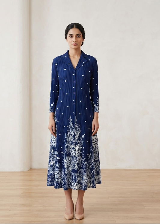 Woman wearing a blue dress with white floral patterns in a minimalistic setting