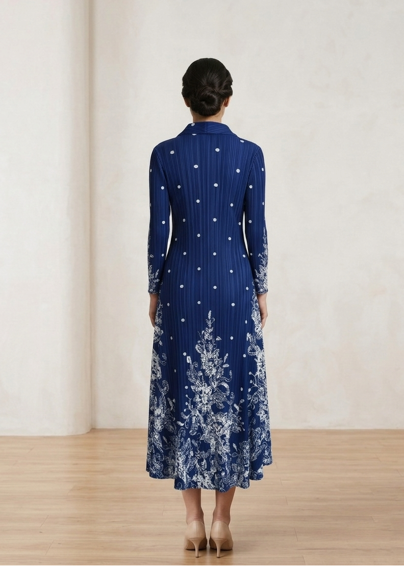 Woman wearing a blue dress with floral patterns in a minimalistic setting