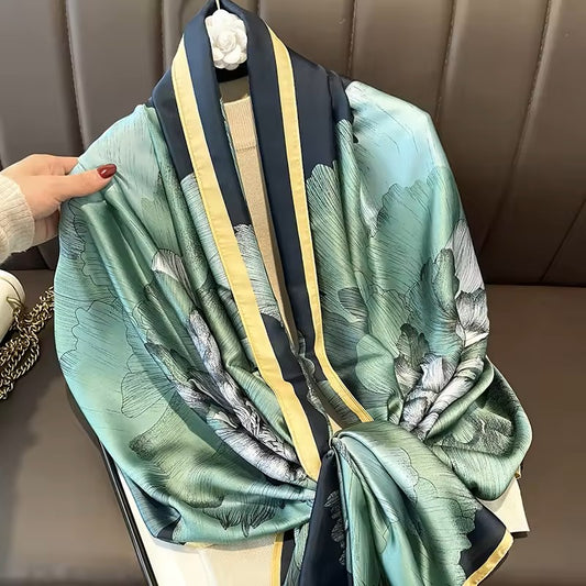 Green floral patterned scarf with black and yellow accents draped over a chair.