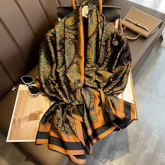 Patterned scarf draped over a chair with bags and sunglasses on a table.