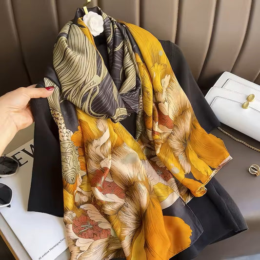 Colorful patterned scarf draped over a chair with a hand holding it.