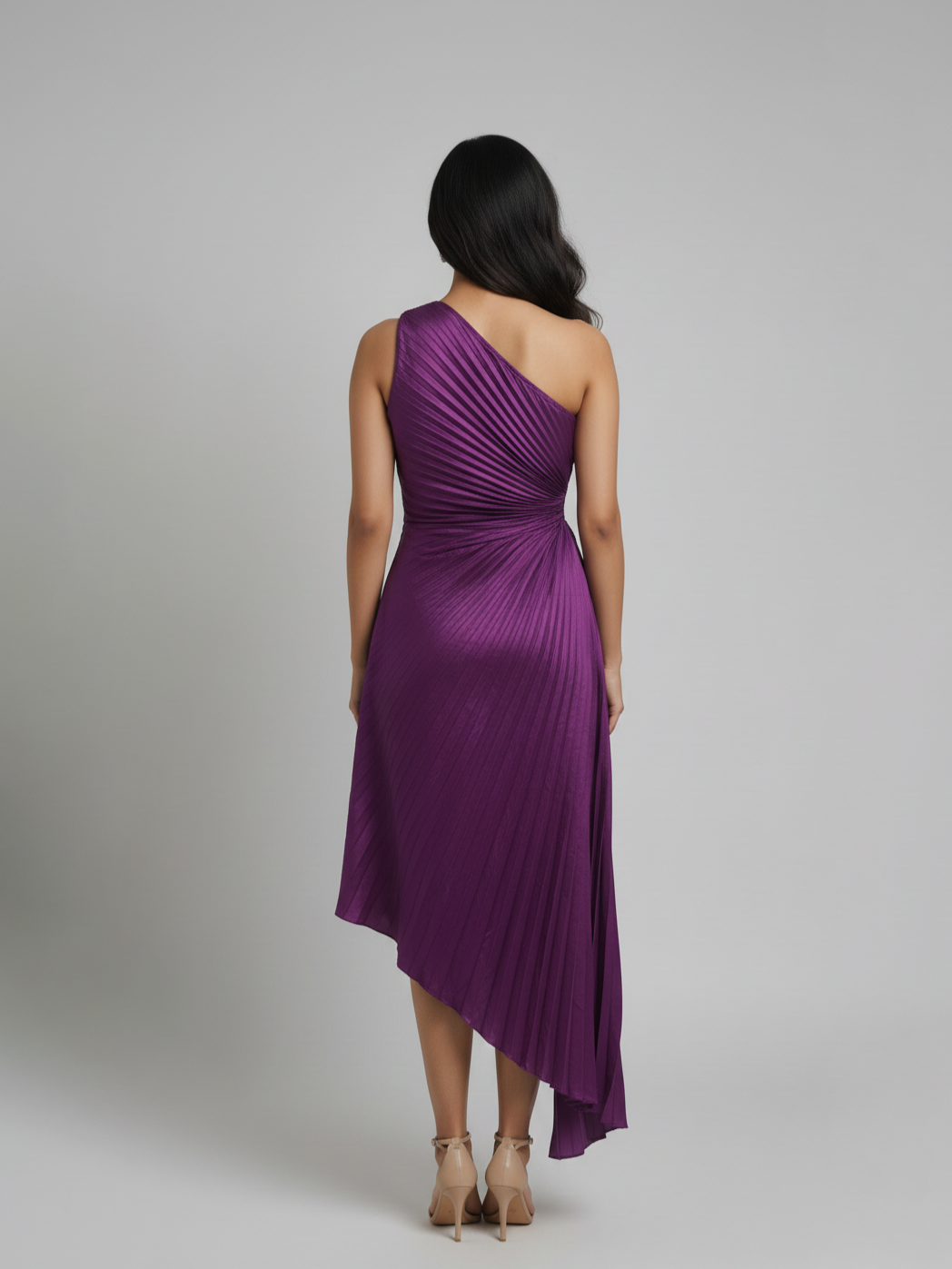 Woman wearing a purple one-shoulder dress on a gray background