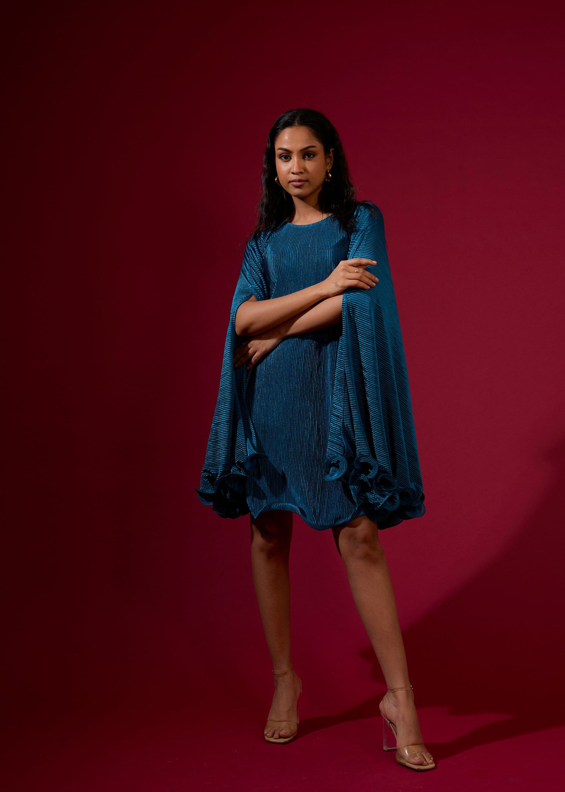 Woman wearing a blue dress against a red background
